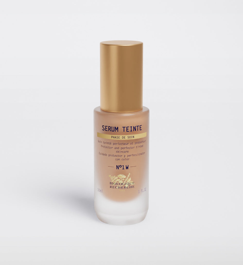 The "Biologique Recherche Serum Teinte N1 Warm" face serum, topped with a gold cap, promises to perfect and protect your skin with a hint of color for impeccable results.