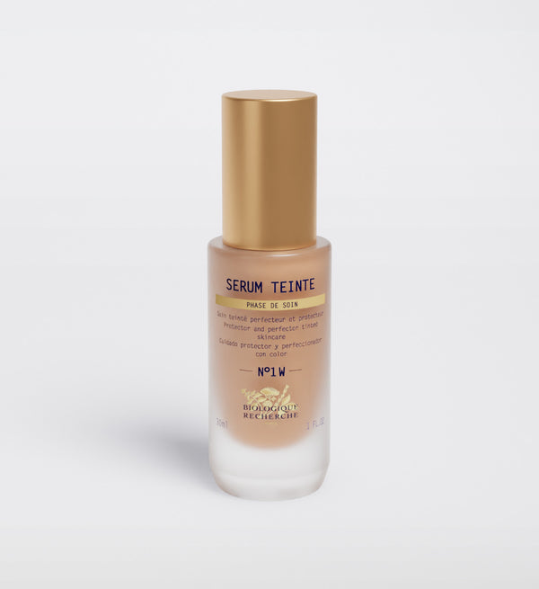 The "Biologique Recherche Serum Teinte N1 Warm" face serum, topped with a gold cap, promises to perfect and protect your skin with a hint of color for impeccable results.