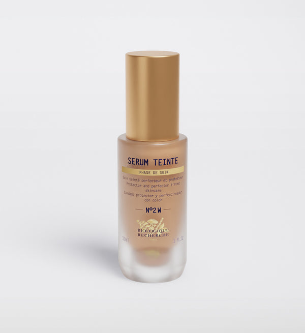 A bottle of Biologique Recherche Serum Teinte N2 Warm, featuring hydrative properties, with a gold cap and frosted glass base on a plain white background.