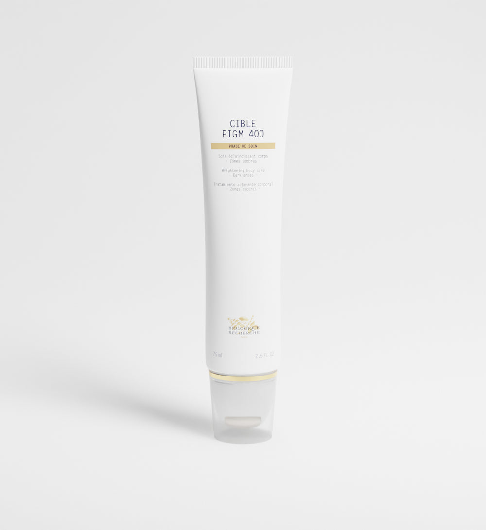 A white tube labeled "Cible PIGM Creme" stands upright on a plain white background, promising precise application to target pigmentation for a more radiant complexion.
