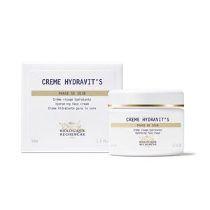 Biologique Recherche Crème Hydravit's moisturizing cream, enriched with Thermal Algae, is in a 50ml white jar with a gold-rimmed lid, elegantly placed beside its packaging.