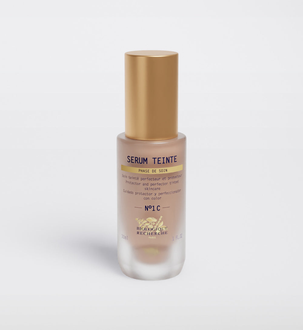 A Biologique Recherche Serum Teinte N1 Cold bottle with a gold cap is displayed on a white background, highlighting its photo-protection qualities. The bold "Noir" on the label is surrounded by French text.
