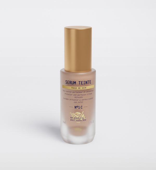 A Biologique Recherche Serum Teinte N1 Cold bottle with a gold cap is displayed on a white background, highlighting its photo-protection qualities. The bold "Noir" on the label is surrounded by French text.