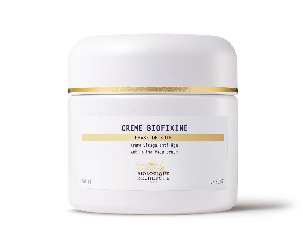 The white jar of Biologique Recherche Crème Biofixine is an anti-aging face cream with advanced myorelax peptide technology and a gold band near the lid. It holds 50 ml (1.7 fl. oz.) and is designed to smooth fine lines effortlessly.