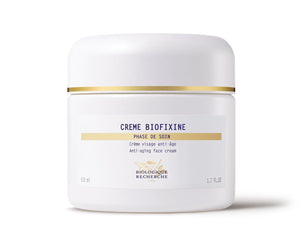 The white jar of Biologique Recherche Crème Biofixine is an anti-aging face cream with advanced myorelax peptide technology and a gold band near the lid. It holds 50 ml (1.7 fl. oz.) and is designed to smooth fine lines effortlessly.