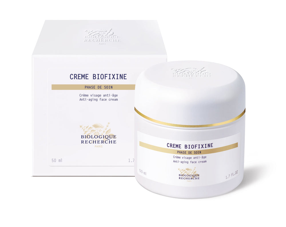 The white jar of Biologique Recherche Crème Biofixine is an anti-aging face cream with advanced myorelax peptide technology and a gold band near the lid. It holds 50 ml (1.7 fl. oz.) and is designed to smooth fine lines effortlessly.