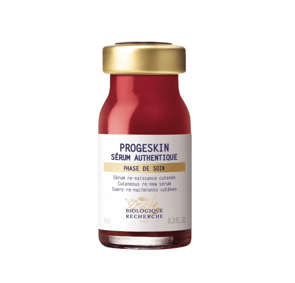 The Biologique Recherche Serum Progeskin, 0.3 oz, features a small bottle with a red bottom and gold cap, providing deep hydration and enhancing skin firmness for revitalization.