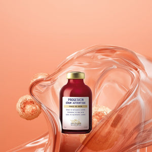 A bottle of Biologique Recherche Serum Progeskin - 1 oz, renowned for its deep hydration, is showcased against a swirling, translucent orange backdrop with floating bubbles.
