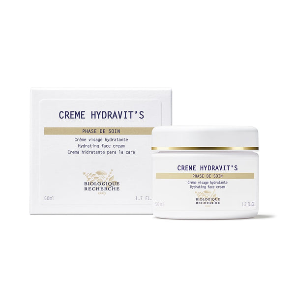 Biologique Recherche Crème Hydravit's moisturizing cream, enriched with Thermal Algae, is in a 50ml white jar with a gold-rimmed lid, elegantly placed beside its packaging.