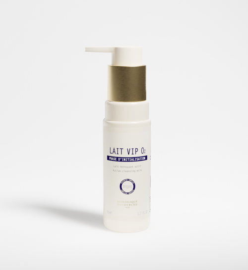 A white bottle of New Formula - Lait VIP 02 Cleansing Milk with a gold pump dispenser, featuring the signature VIP O2 Complex, stands upright on a plain white background.