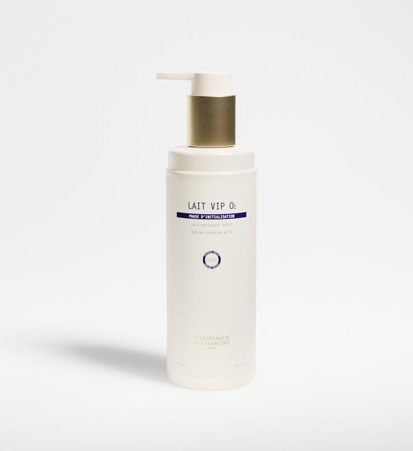 A white bottle with a gold pump labeled "New Formula - Lait VIP 02 Cleansing Milk" by Biologique Recherche stands upright against a plain white background, highlighting its oxygenating cleansing benefits.
