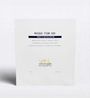 The Biologique Recherche Masque PIGM 400, a brightening face mask targeting uneven pigmentation and enhancing radiance, is shown in its white packet against a plain background.