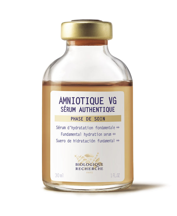 The product, "Amniotique VG Sérum Authentique," comes in a 30 ml (1 oz) clear bottle with multilingual labeling and features a gold-colored cap.