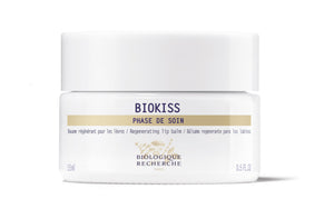 A white jar of Biologique Recherche BioKiss Nourishing Lip Balm, labeled "Phase de Soin," features botanical lipids for nourishing care and contains 0.5 fl oz.