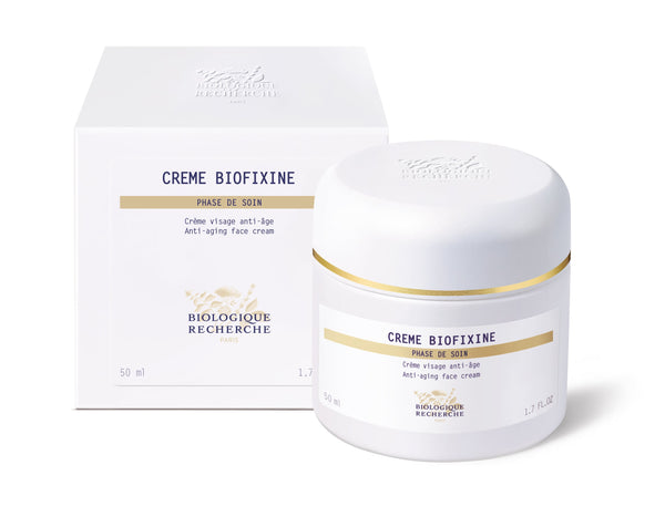 Jar and box of REVIEW Biologique Recherche Crème Biofixine, an anti-aging face cream with a luxurious texture, displayed on a white background, emphasizing its rejuvenating properties for youthful skin.