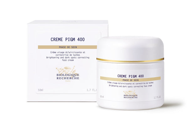 A 50ml jar and box of Biologique Recherche Crème PIGM 400 face cream with gold accents, designed to brighten the complexion and reduce pigmentation marks.