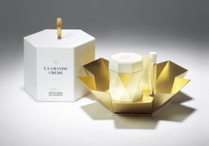 The luxurious Biologique Recherche La Grande Crème, an anti-aging skincare product, showcases a geometric cream jar alongside an open golden box and a closed white box with its name. It's skillfully crafted with professional cosmetics expertise for cellular regeneration.