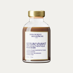 A bottle of Serum Vivant featuring a gold cap and a white label with product details, formulated as a serum to refine skin texture and support blemish-prone skin.