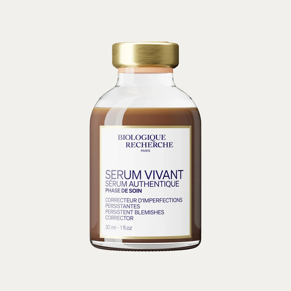 A bottle of Serum Vivant featuring a gold cap and a white label with product details, formulated as a serum to refine skin texture and support blemish-prone skin.
