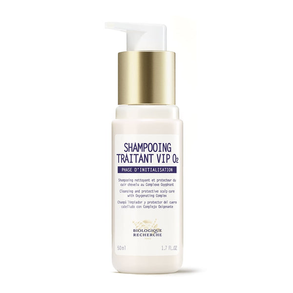 A travel-size bottle of Biologique Recherche Shampooing Traitant VIP O2, an oxygenating antipollution shampoo for fragile hair, features a white pump dispenser and gold cap. The label includes text in both French and English.