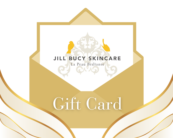 The Jill Bucy Skincare Gift Certificate, featuring an ornate design with two yellow birds, comes in an elegantly wrapped golden envelope with wing-like accents, ideal for indulging in luxurious French skincare.